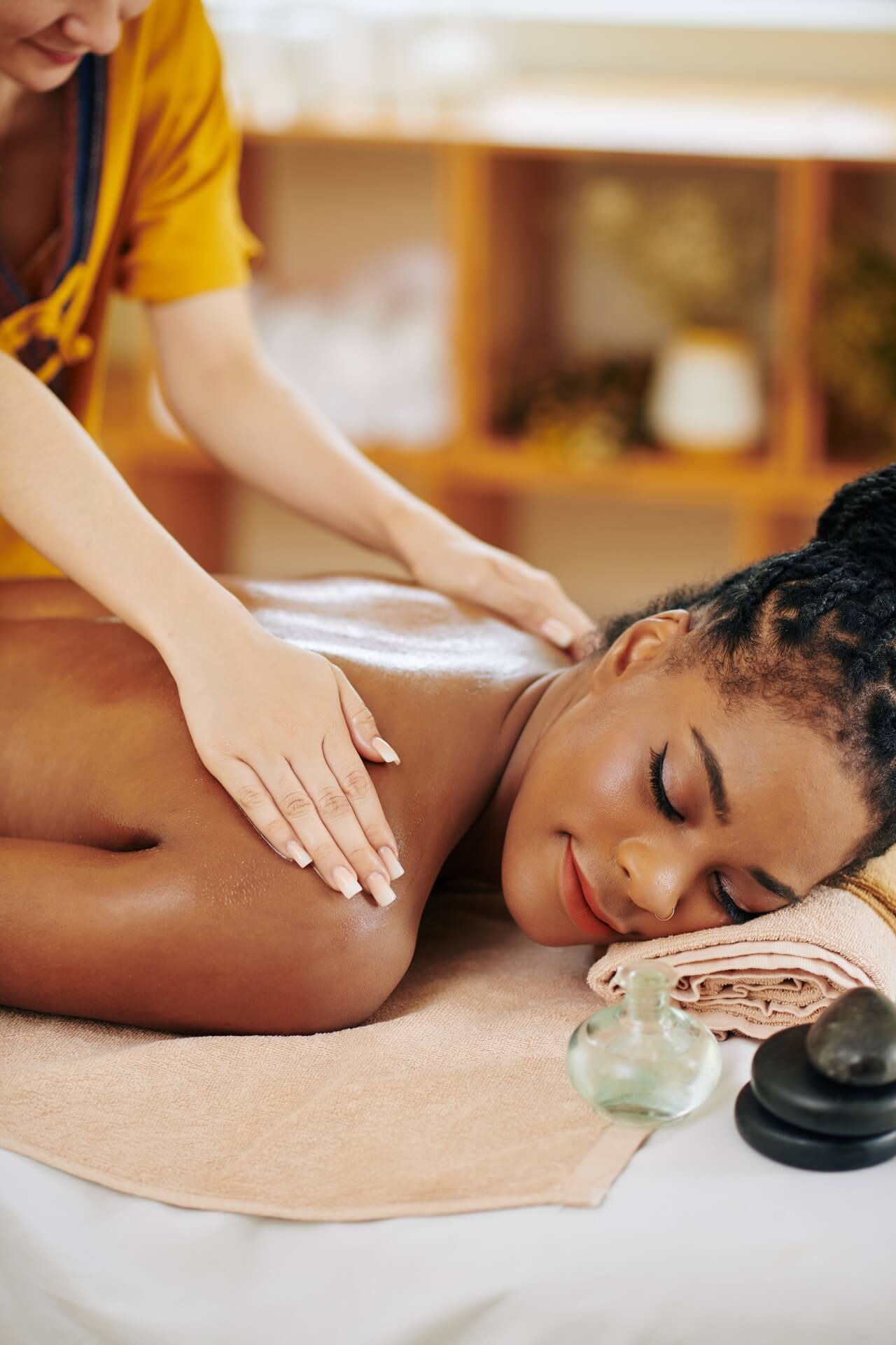 A woman enjoying back massage with Thai balm and oil